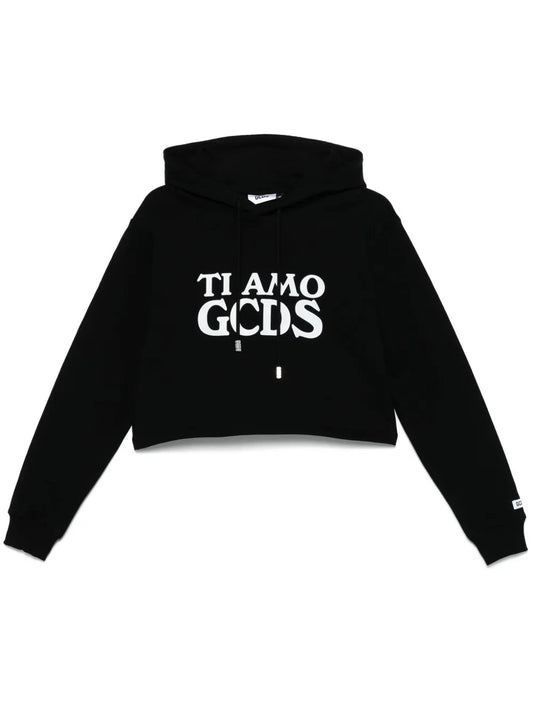 【GCDS クロップド フーディ】 フロントに“Ti Amo GCDS”のプリントを施した、遊び心あふれる一着。 クロップド丈×オールブラックの組み合わせで、クールかつフェミニンな雰囲気に。 100%コットンで着心地も抜群。 ストリートラグジュアリーを楽しむなら、この一枚。